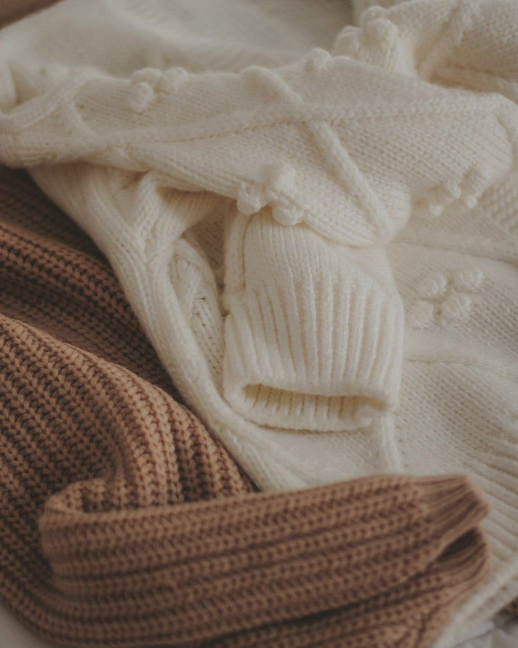 Cream and camel knit sweaters in soft light