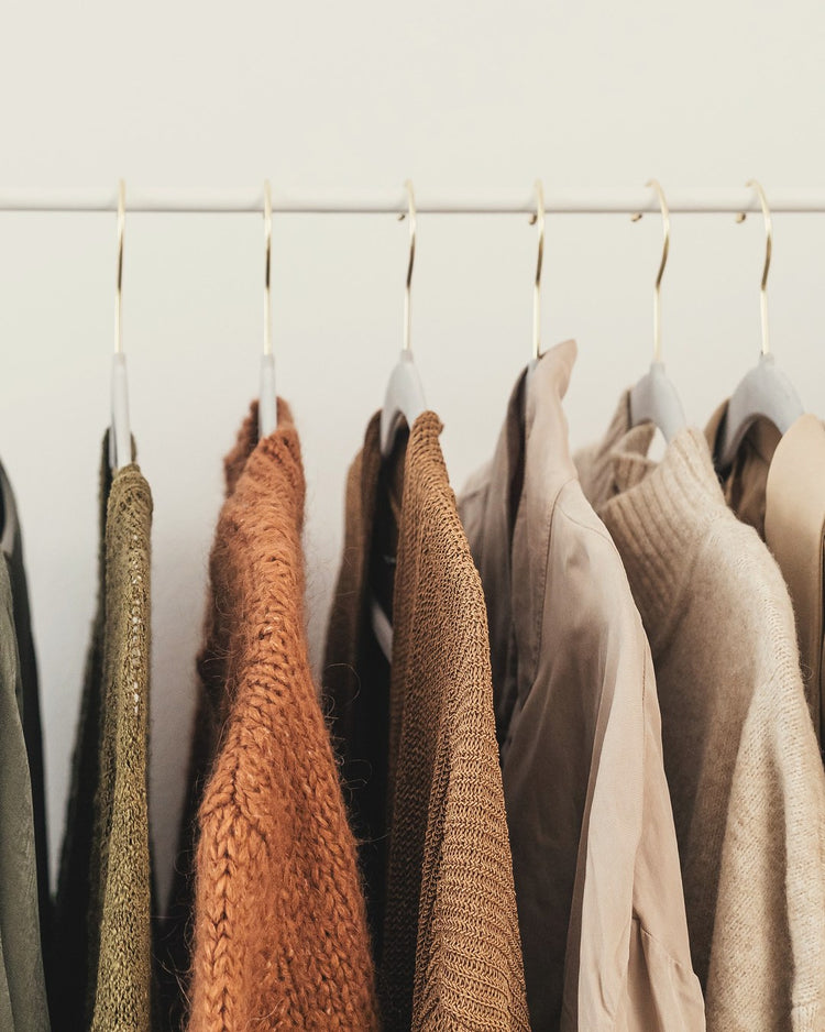 Rail of camel, rust, olive and cream pieces against a light wall